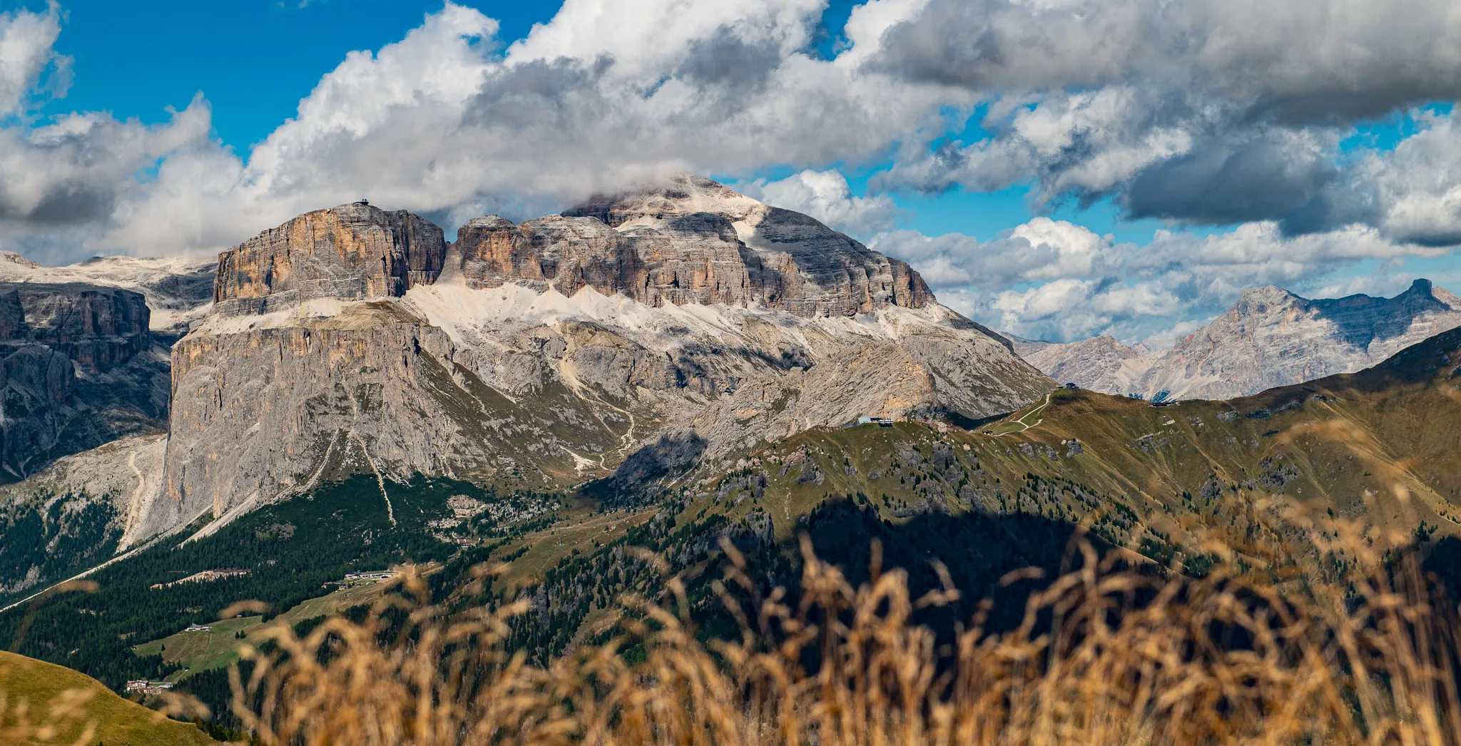 Sass Pordoi mountain peak and Sella massif on a cloudy sunny afternoon, Dolomites, Italy.